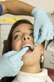 Hygienist cleaning patient's teeth